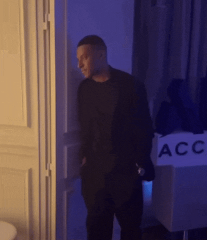 a man is standing in front of a sign that says acc on it