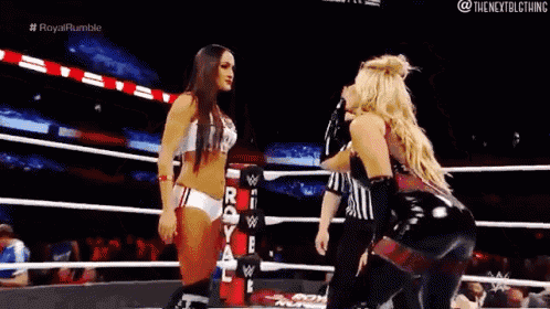 two women are wrestling in a ring and one of them is wearing a bikini top .