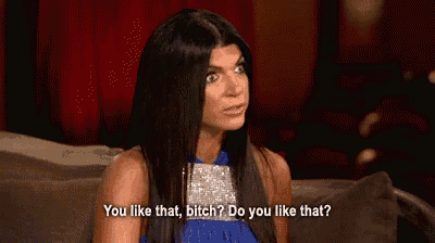 a woman in a blue dress is sitting on a couch and saying `` you like that bitch ? do you like that ? ''