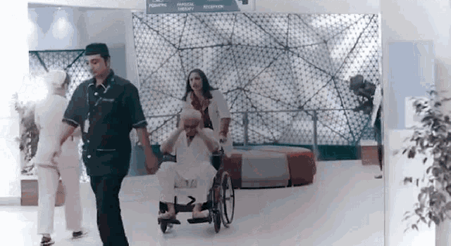 an elderly woman in a wheelchair is being pushed by a nurse .