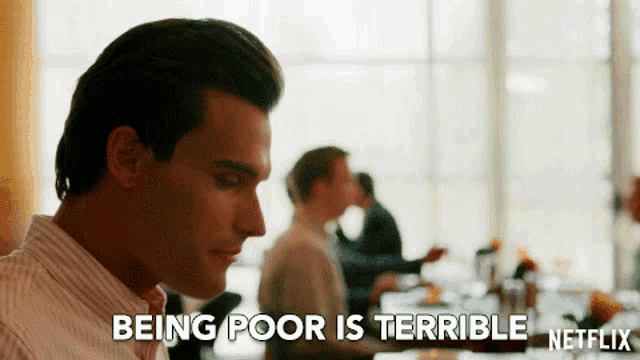 a man is sitting at a table with the words " being poor is terrible " on the bottom