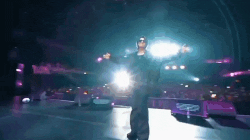 a man is standing on a stage with a microphone in his hand