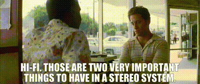 a man and a woman are talking in front of a stereo system