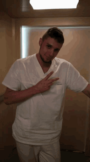 a man wearing a white scrub top with a name tag that says ' stefan ' on it