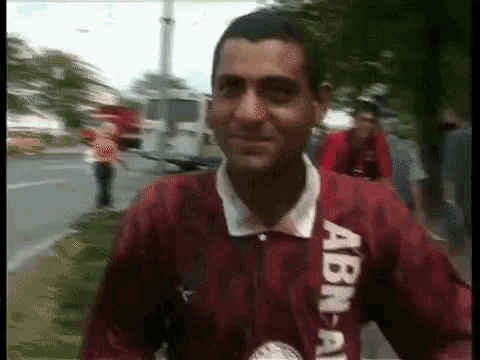 a man wearing a red shirt with abn on the sleeve