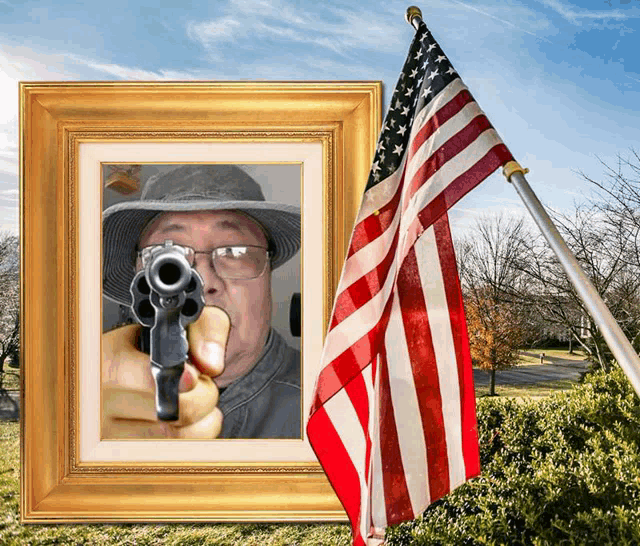 a picture of a man pointing a gun with an american flag behind him