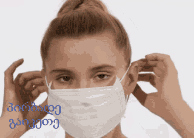 a woman wearing a white face mask with a blue background that says ' georgia ' on it