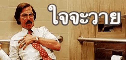 a man in a white shirt and red tie is sitting in a bathroom with a foreign language written above him