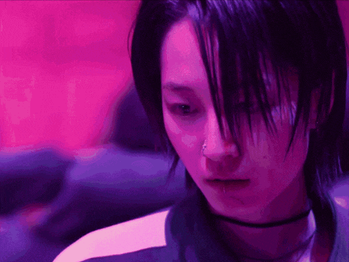 a close up of a person 's face with purple lights behind them