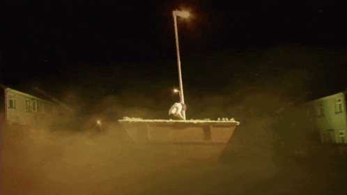 a statue of a man standing on top of a dumpster
