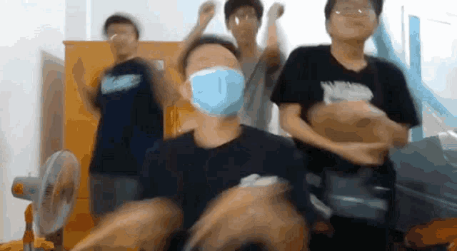 a group of young men wearing face masks are dancing