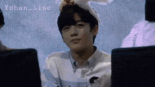 a young man wearing a bunny hat is sitting in front of a computer screen with yohan_line written on it