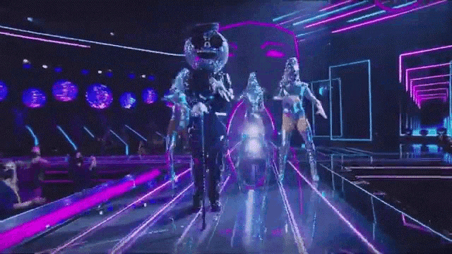 a group of people are standing on a stage in a dark room .