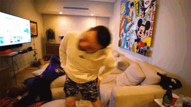 a man dancing in front of a mickey mouse painting that says be happy