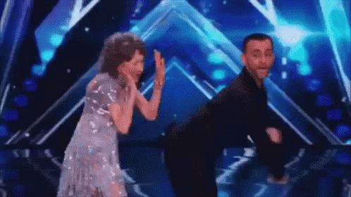 a man and a woman are dancing on a stage on a blue background .