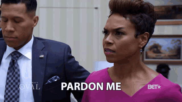 a woman in a purple shirt says pardon me in front of a man in a suit