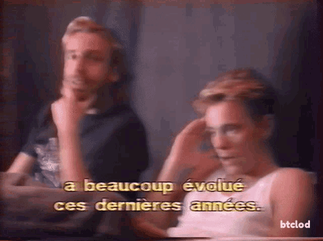a man and a woman are sitting next to each other with a caption that says a beaucoup
