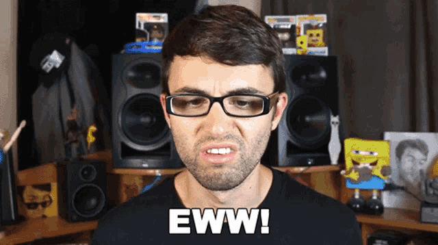 a man with glasses says eww in front of a speaker