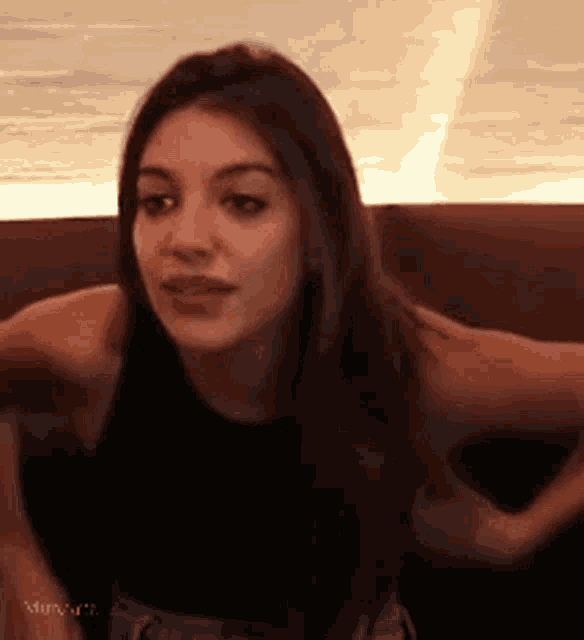 a woman is sitting in a chair with her hands on her hips and making a funny face .
