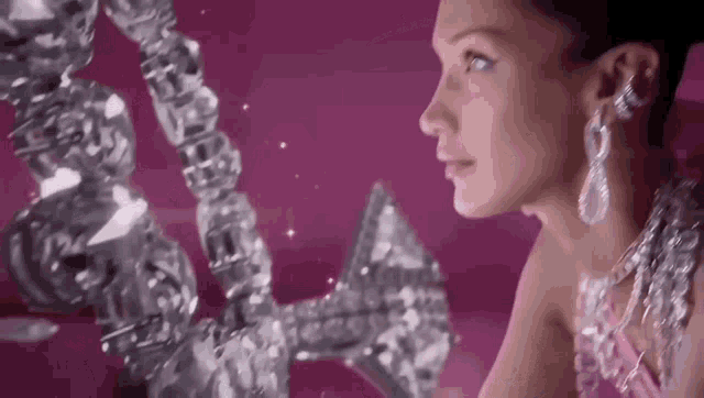 a woman is wearing a necklace and earrings and looking at a mirror .
