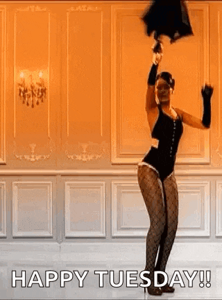 a woman in a black bodysuit is holding an umbrella in her hand and dancing in a room .