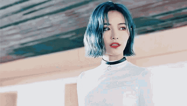 a woman with blue hair is wearing a choker