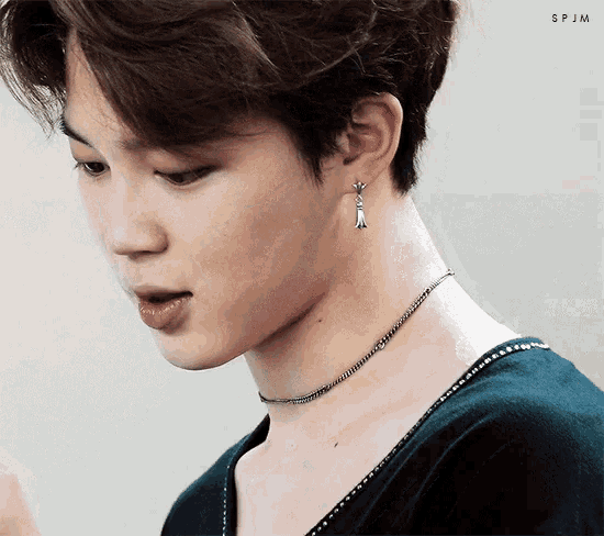 a close up of a person wearing a necklace and earring