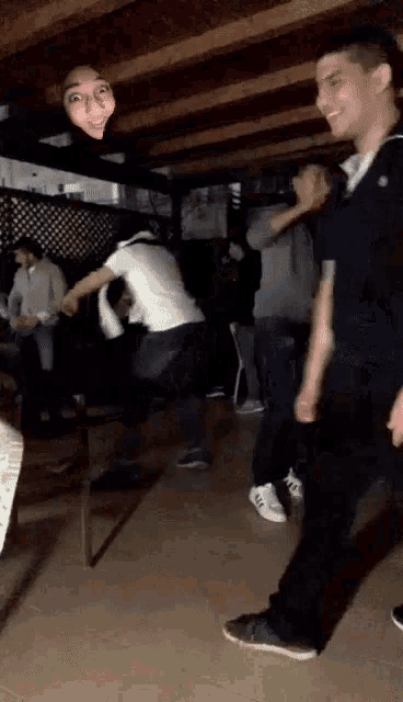 a group of people are dancing in a dark room with a woman making a funny face