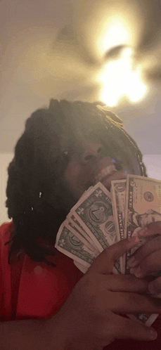 a man with dreadlocks is holding a bunch of money in his hands