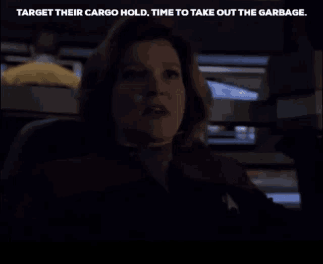 a woman is sitting in a dark room with the words target their cargo hold time to take out the garbage below her