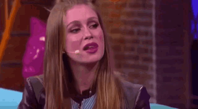a woman is sticking her tongue out while talking into a microphone on a stage .