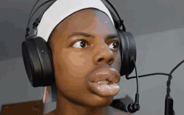 a young man wearing headphones and a headband has a big mouth