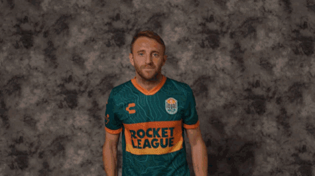 a man wearing a green and orange jersey that says rocket league on it