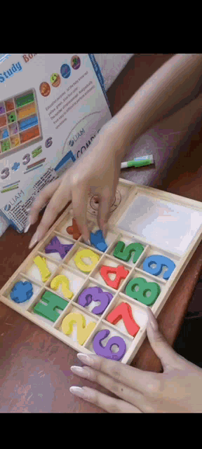 a person playing with a wooden tray of numbers