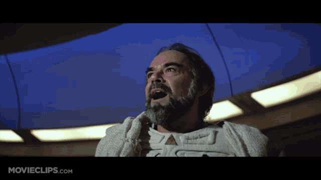 a man with a beard is screaming in a movie clip