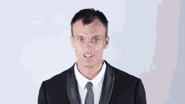 a man in a suit and tie adjusts his ear buds
