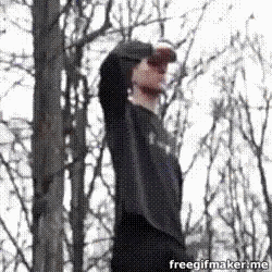 a man in a black hoodie is standing in the woods with a freegifmaker.me logo in the corner