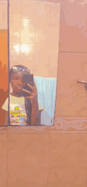 a person is taking a picture of themselves in a bathroom mirror .