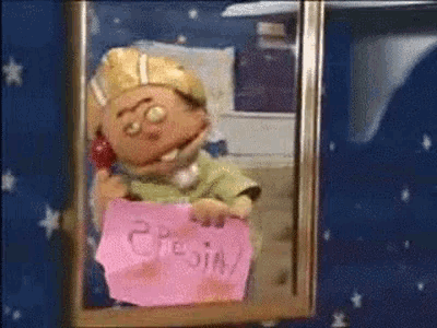a puppet is holding a pink piece of paper that says " gracias "
