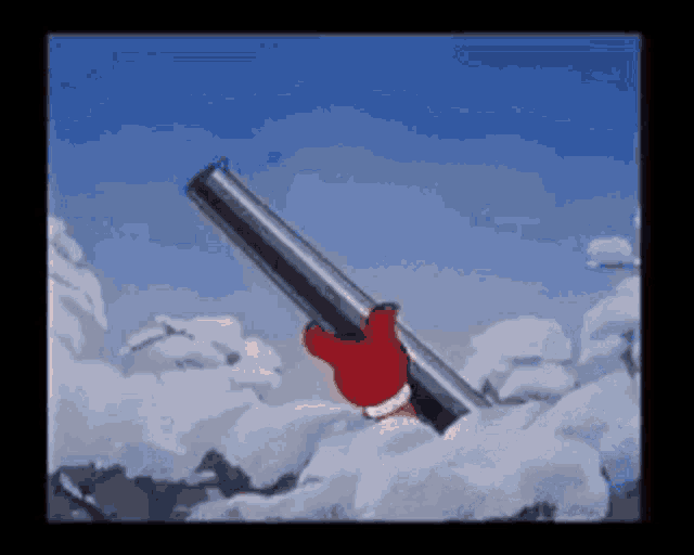 a person in a red glove is holding a shotgun in the snow
