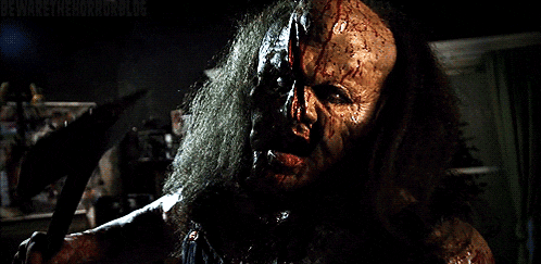 a man with blood on his face is holding a large axe in his hand