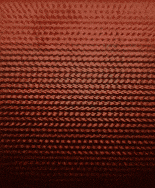 a close up of a red knitted pattern on a dark background