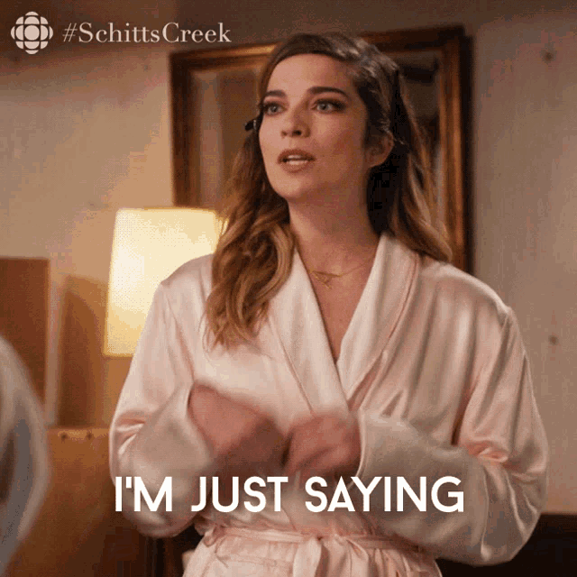 a woman in a bathrobe says " i 'm just saying "