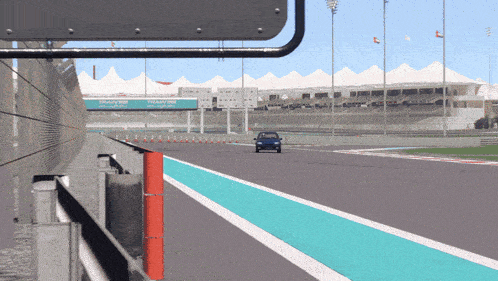 a car is driving down a race track with a sign that says dubai