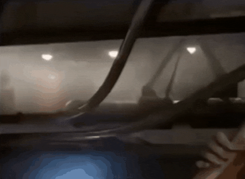 a blurred image of a car windshield with a few lights visible