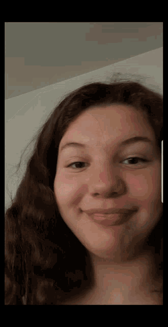 a close up of a girl 's face with a slight smile