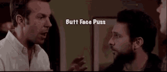 a group of men are standing next to each other in a room talking to each other .