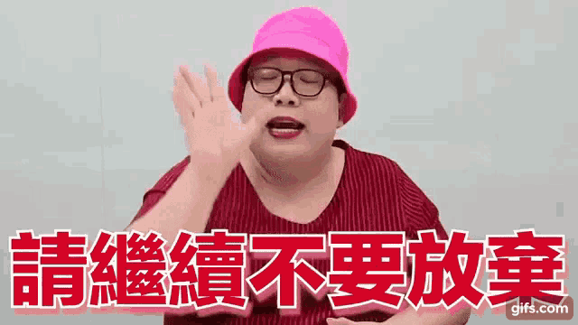 a man wearing a pink hat and glasses is making a funny face in chinese .