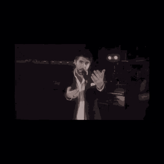 a man in a suit and tie is standing in front of a microphone