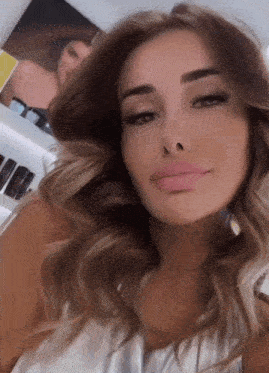 a woman with long brown hair is taking a selfie